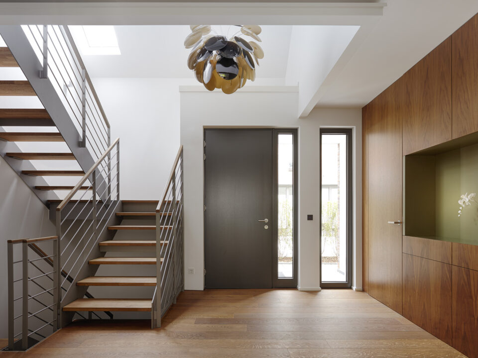 Plank floor and walnut wall covering in home near staircase